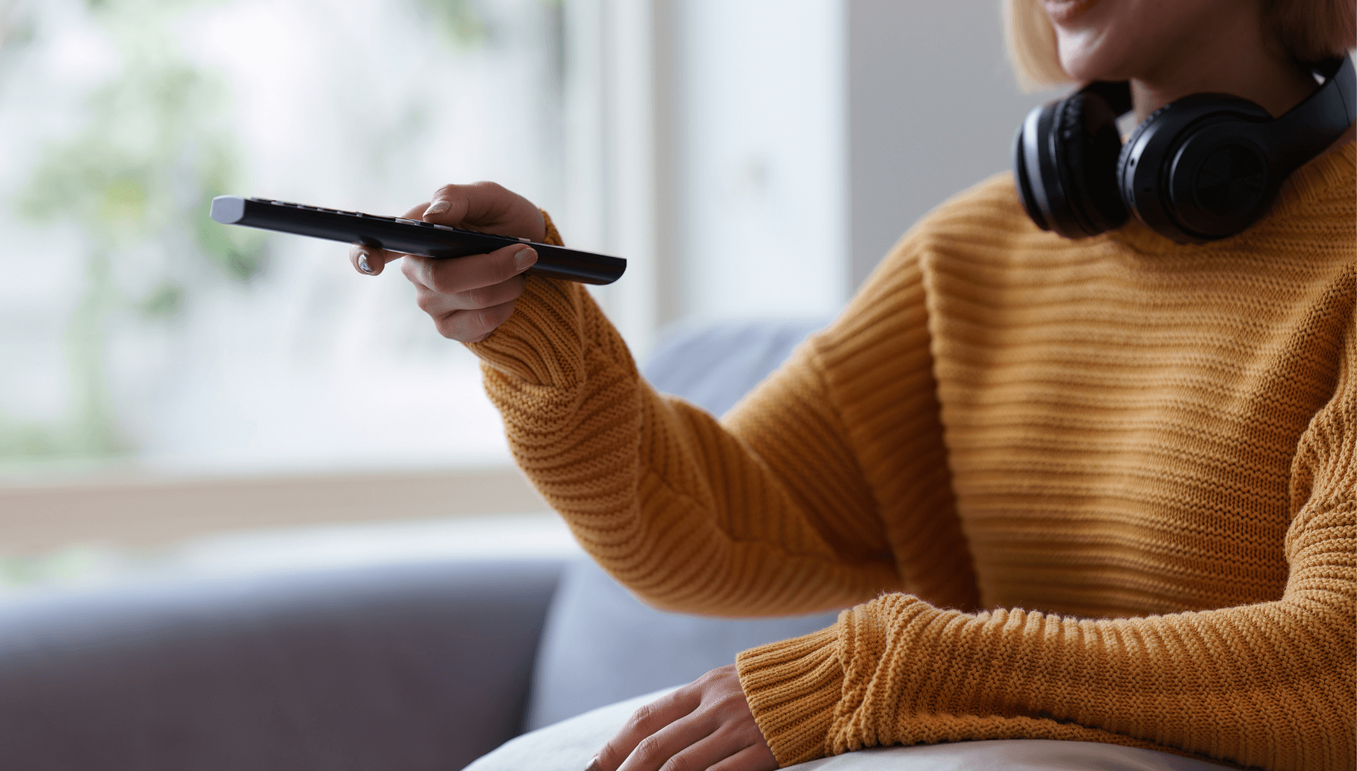 Lady Wearing Headphones holding Remote Control